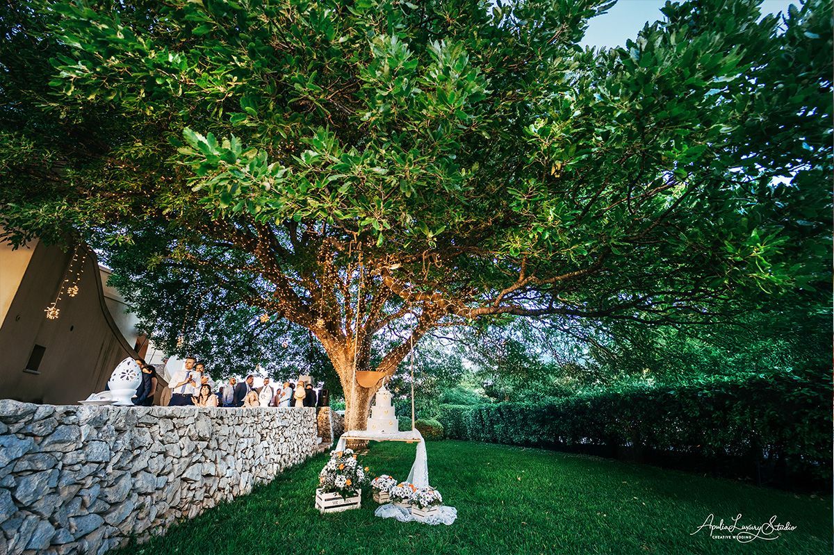 La quercia secolare di Cala dei Balcani con le luci tra i rami e la torta nuziale appesa all&rsquo;altalena &mdash; matrimonio a Santa Cesarea Terme, Salento