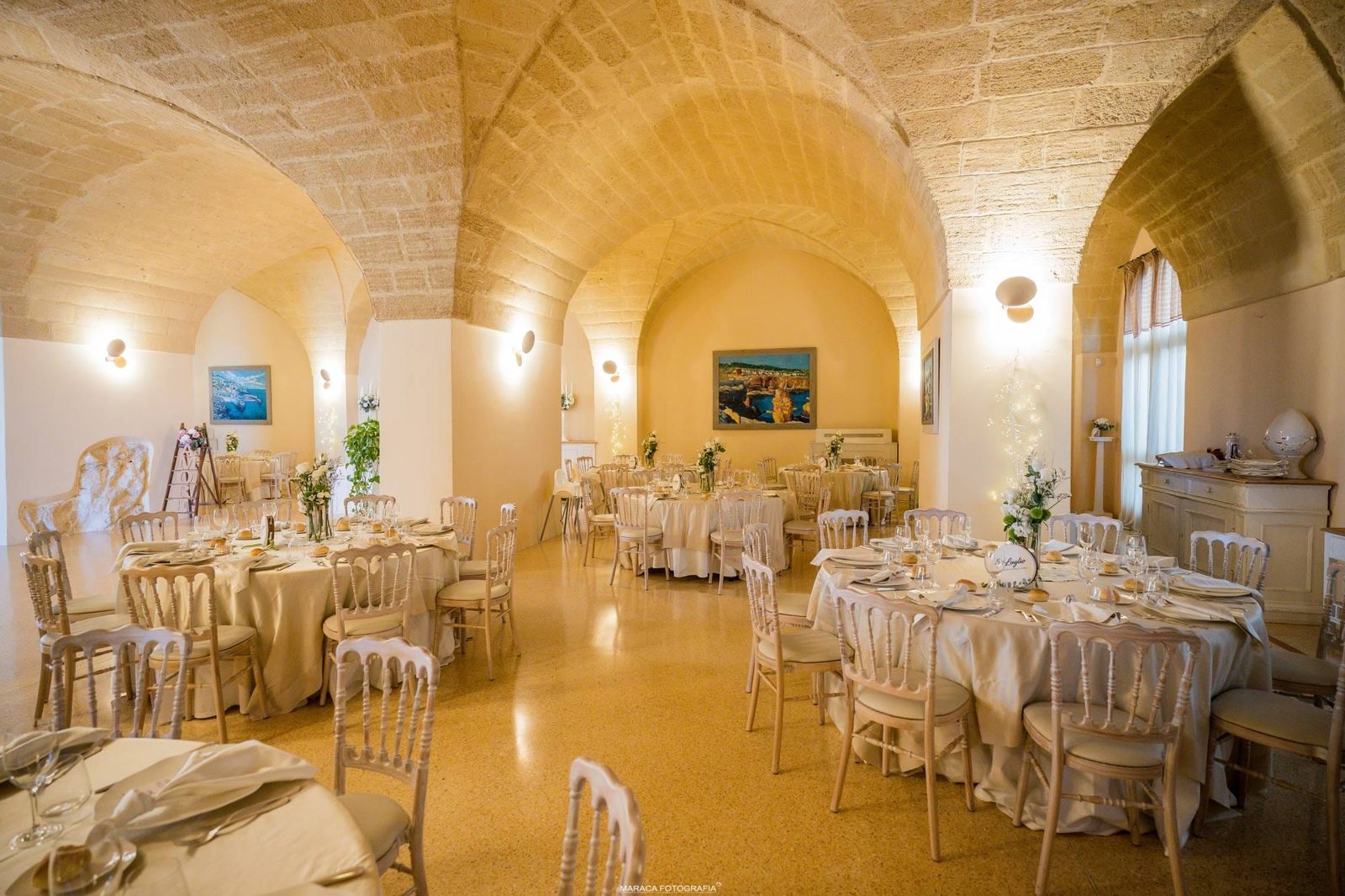 Sala per banchetti con volte in pietra leccese e quadri marini — location matrimoni Cala dei Balcani, Santa Cesarea Terme, Salento